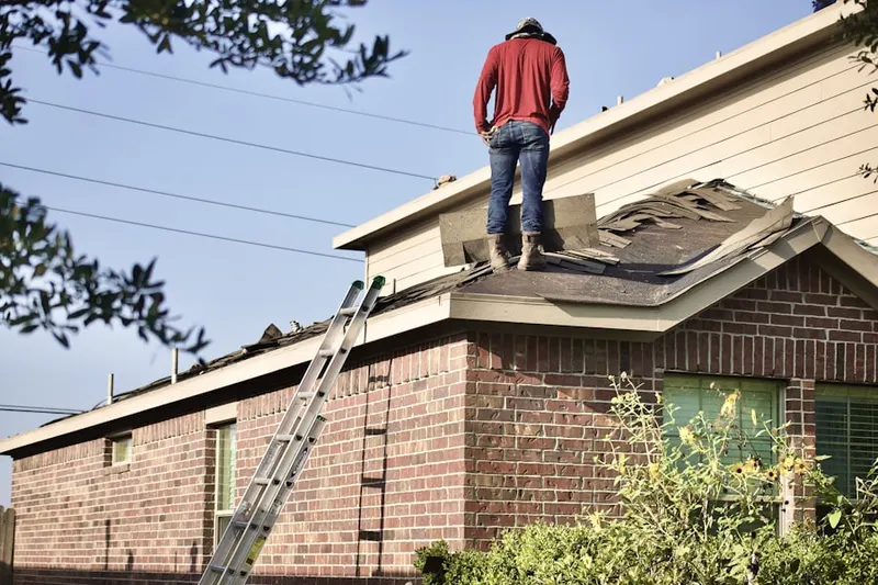 Professional roofer working on a residential roof in Monmouth Hills